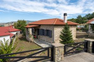 a small stone house with a red roof at Doukas Village House in Gávros