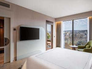 a hotel room with a bed and a flat screen tv at Swissôtel Tbilisi in Tbilisi City