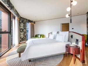 een slaapkamer met een groot wit bed en een tafel bij Swissôtel Tbilisi in Tbilisi City +95 foto's