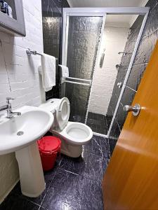 um banheiro com vaso sanitário, pia e chuveiro em Aparta Suite Torre De Prado 305 em Medellín