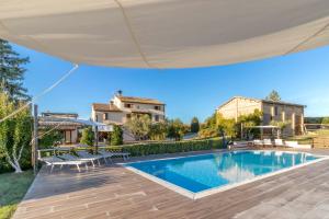 a villa with a swimming pool and a house at Country House Binnella in Cingoli