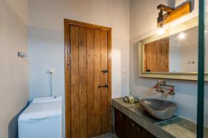 a bathroom with a sink and a wooden door at Doukas Village House in Gávros +14 photos