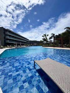 a large swimming pool with blue tiles in a building at Flat Beach Summer Residence Praia do Cupe - Porto de Galinhas in Porto De Galinhas