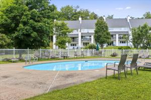 a swimming pool with chairs and a building in the background at Lodge Condo 35 in Stowe Fork