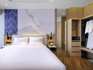 a bedroom with a large bed and a walk in closet at Novotel Rayong Star Convention Centre in Rayong