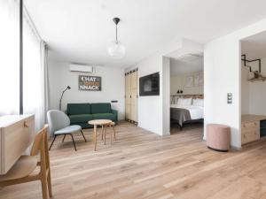 a living room with a green couch and a bed at Oru Hub Hotel Tallinn - Handwritten Collection in Tallinn +121 photos