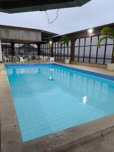 Una gran piscina con azulejos azules en un edificio. en Flat praia Vila Velha ES, en Vila Velha