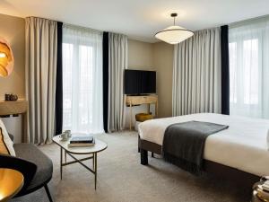 een hotelkamer met een groot bed en een tafel bij Le Saint Gervais Hotel & Spa Handwritten Collection in Saint-Gervais-les-Bains