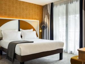 een slaapkamer met een groot bed met witte kussens bij Le Saint Gervais Hotel & Spa Handwritten Collection in Saint-Gervais-les-Bains +110 foto's