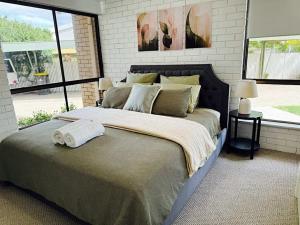 a bedroom with a large bed with two towels on it at Young unit1 Water Views in Nagambie