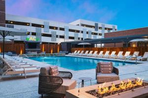 Una piscina con tumbonas y un hotel. en AC Hotel by Marriott Waco Downtown, en Waco