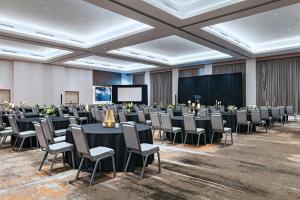 una sala de conferencias con mesas, sillas y una pantalla en AC Hotel by Marriott Waco Downtown, en Waco 109 fotos más