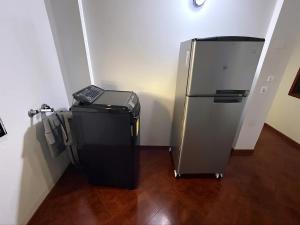 um pequeno frigorífico num canto de um quarto em Aparta Suite Torre De Prado 305 em Medellín