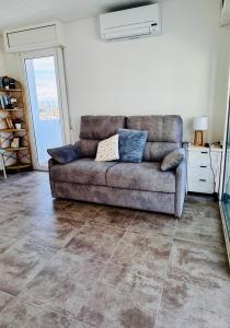 a couch sitting in a living room with a tile floor at Estudio Moderno la mejor vista al puerto deportivo in Empuriabrava