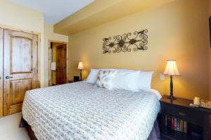 a bedroom with a bed with a white comforter at Aspens 4607 in Big White +24 photos