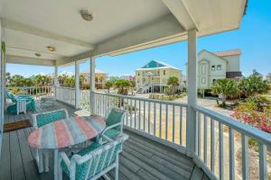 a patio with a table and chairs on a deck at Sea La Vie in Gulf Shores +64 photos