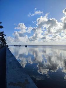 a large body of water with clouds in the sky at Colonial House in Porto Seguro