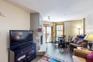 a living room with a flat screen tv and a fireplace at Buffalo Lodge 8351 in Keystone