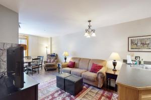 a living room with a couch and a tv and a table at Buffalo Lodge 8351 in Keystone