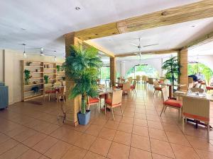 a restaurant with tables and chairs and plants at Coronado Luxury Club and Suites,Oasis in El Quije