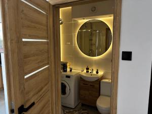 a bathroom with a sink and a washing machine at Apartament w Centrum Miasta in Brodnica