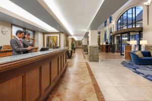 two people standing at a bar in a lobby at Millennium Hotel Queenstown in Queenstown