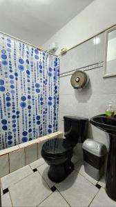 een badkamer met een zwart toilet en een wastafel bij EL TUMI - Aeropuerto in Lima
