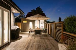 a patio with a table and an umbrella at Modern Swedish villa in Hagby