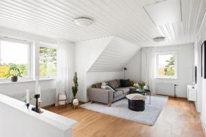 a white living room with a couch and a table at Modern Swedish villa in Hagby