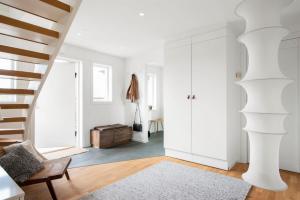a living room with a staircase and white cabinets at Modern Swedish villa in Hagby