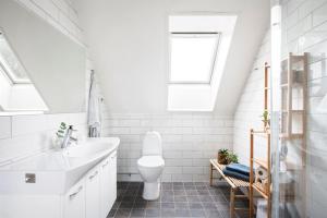 a white bathroom with a sink and a toilet at Modern Swedish villa in Hagby +21 photos