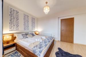 a bedroom with a bed and a chandelier at Ski Slope Getaway at Grand Monastery by Flat Manаger in Pamporovo
