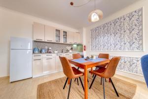 a kitchen with a table and chairs and a refrigerator at Ski Slope Getaway at Grand Monastery by Flat Manаger in Pamporovo +9 photos