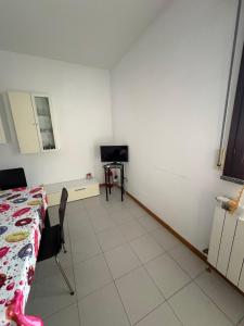 a room with a table and a bed and a television at Bartoli 8, Viserbella di Rimini in Rimini