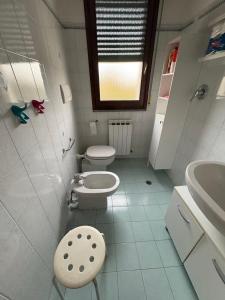 a white bathroom with two toilets and a sink at Bartoli 8, Viserbella di Rimini in Rimini +11 photos