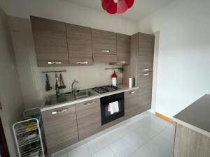 a kitchen with wooden cabinets and a sink at Bartoli 8, Viserbella di Rimini in Rimini