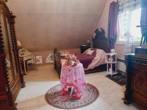 a small room with a bed and a table at Les bosquets chambre d hôtes in Caugé