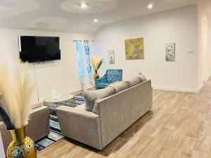 a living room with a couch and a flat screen tv at The Evergreen Escape in Rosenberg
