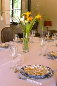 une table avec des verres et un vase de fleurs sur elle dans l'établissement Authentique moulin à eau du ⅫⅠe siècle, à La Vernelle 26 autres photos