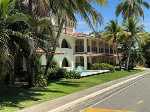 a large house with a swimming pool and palm trees at Coronado Luxury Club and Suites,Oasis in El Quije