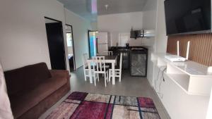 Una sala de estar con un sofá y una mesa y una cocina. en Horizonte Azul - Penha SC - Beto Carrero, en Penha