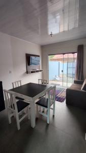 Una sala de estar con una mesa y sillas y un sofá. en Horizonte Azul - Penha SC - Beto Carrero, en Penha