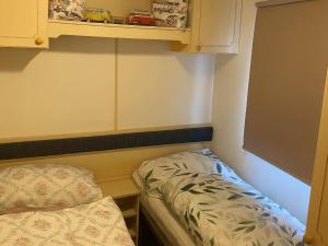a small bedroom with a bed and a cabinet at Brynowen Holiday Park - Holiday Accommodation 19041 in Borth