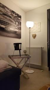 a room with a table and a lamp and a chair at Villa AIMÉ SALMCHÂTEAU in Vielsalm