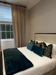 a bedroom with a large bed with blue pillows at The Victorian Residence in Moffat