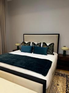 a bedroom with a large bed with blue pillows at The Victorian Residence in Moffat
