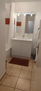 a bathroom with a sink and a tub and a mirror at Appartement face à la Gare in Annemasse