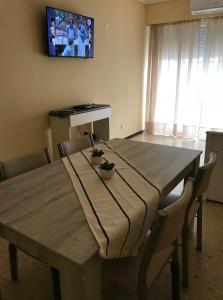 a dining room table with chairs and a television on the wall at Vista al mar in Mar del Plata