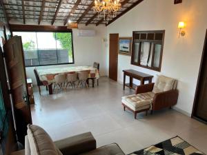 a living room with a table and chairs at Chalé com Ar Condicionado Praia Seca in Araruama