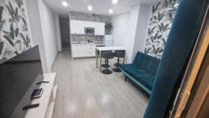 un salon avec un canapé bleu et une cuisine dans l'établissement PAKITO TENERIFE Mareverde, à Adeje